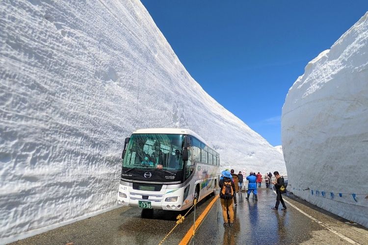 A bus in between two snow walls. 