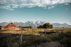 A barn with mountains in the background.