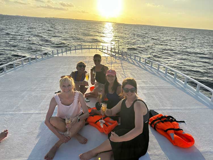 The author and her friends on a sunset cruise in the Maldives. Photo courtesy Janna Graber
